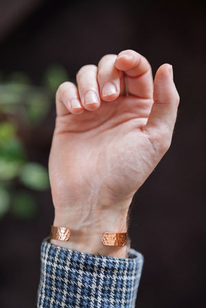 Kopero Kobberarmbånd Hamret, om håndleddet, med åben hånd og armbåndets ender synlige