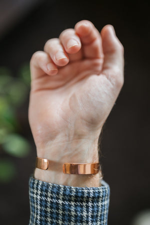 Kopero Kobberarmbånd Glat, om håndleddet, med åben hånd og armbåndets ender synlige