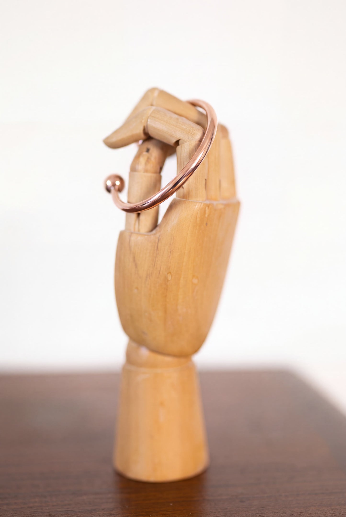 Kopero Koperen Armband Rond op een houten sieradenhand