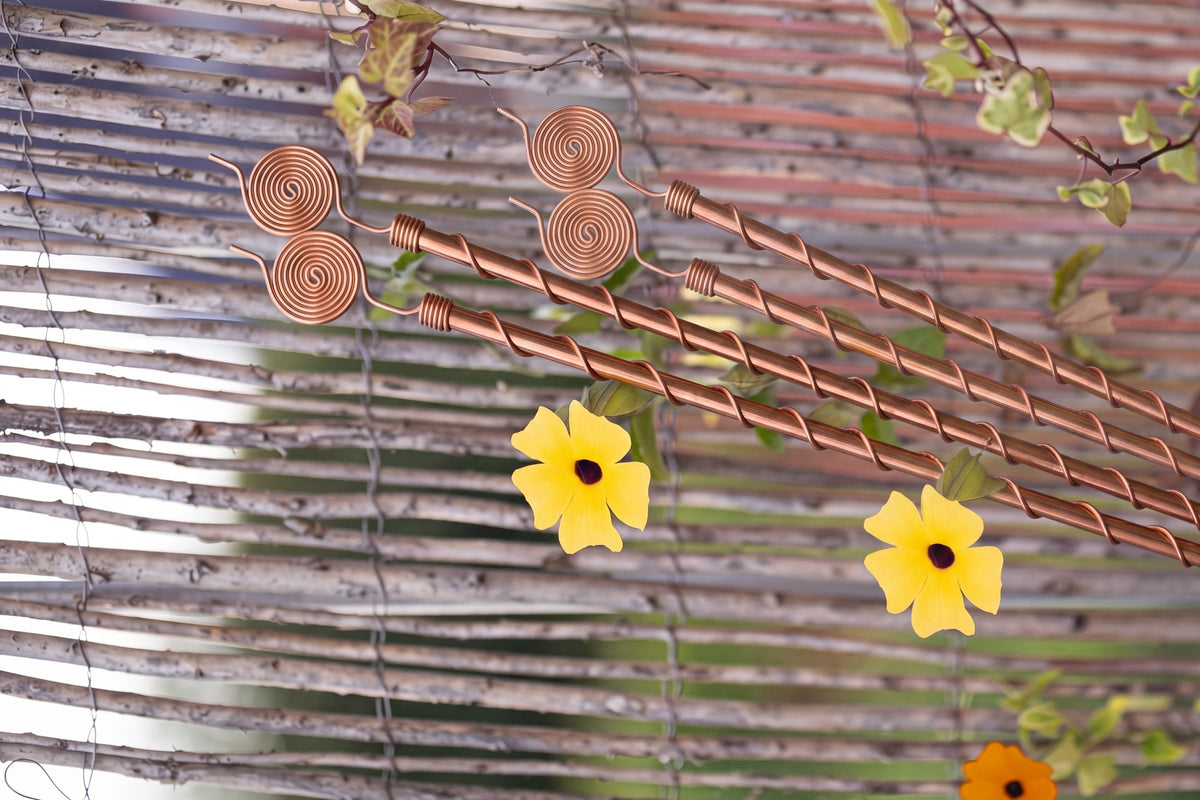 Kopero Elektrokultur-antenner på 60 cm langs et flettet plankeærk med blomstrende klatreplante