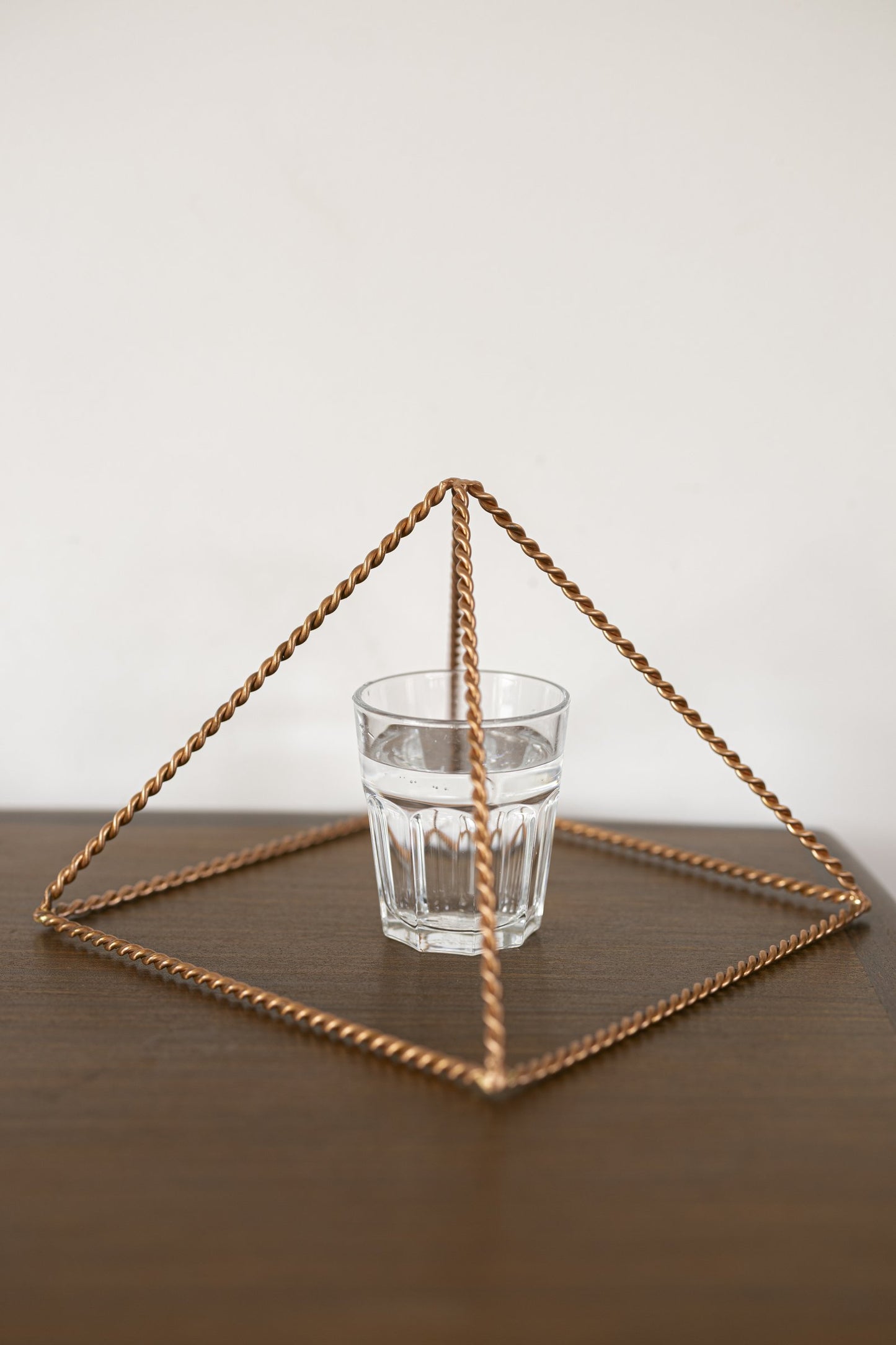Kopero Kobberpyramide Energizer Snøet Stor (23,56 cm) over et glas vand