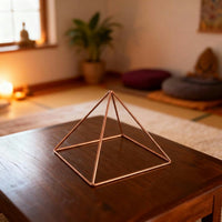 Kopero Kobberpyramide Energizer Glat Lille (14,56 cm) på et sofabord i et meditationsrum