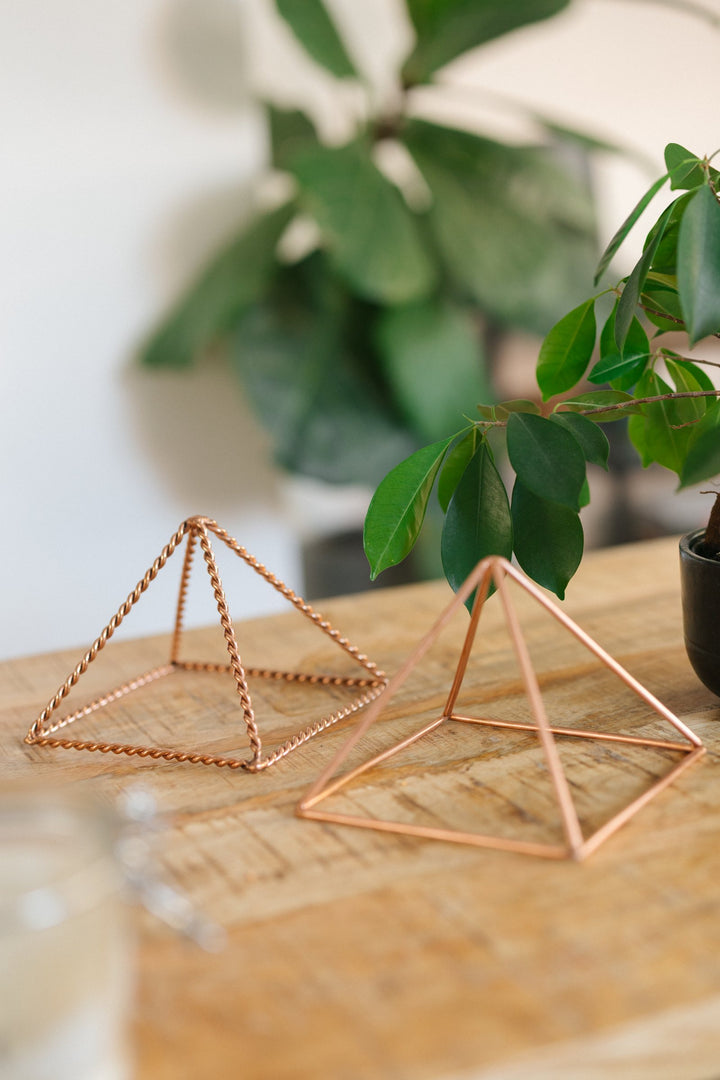 Den lille glatte og den lille snoede pyramide side om side på et træbord