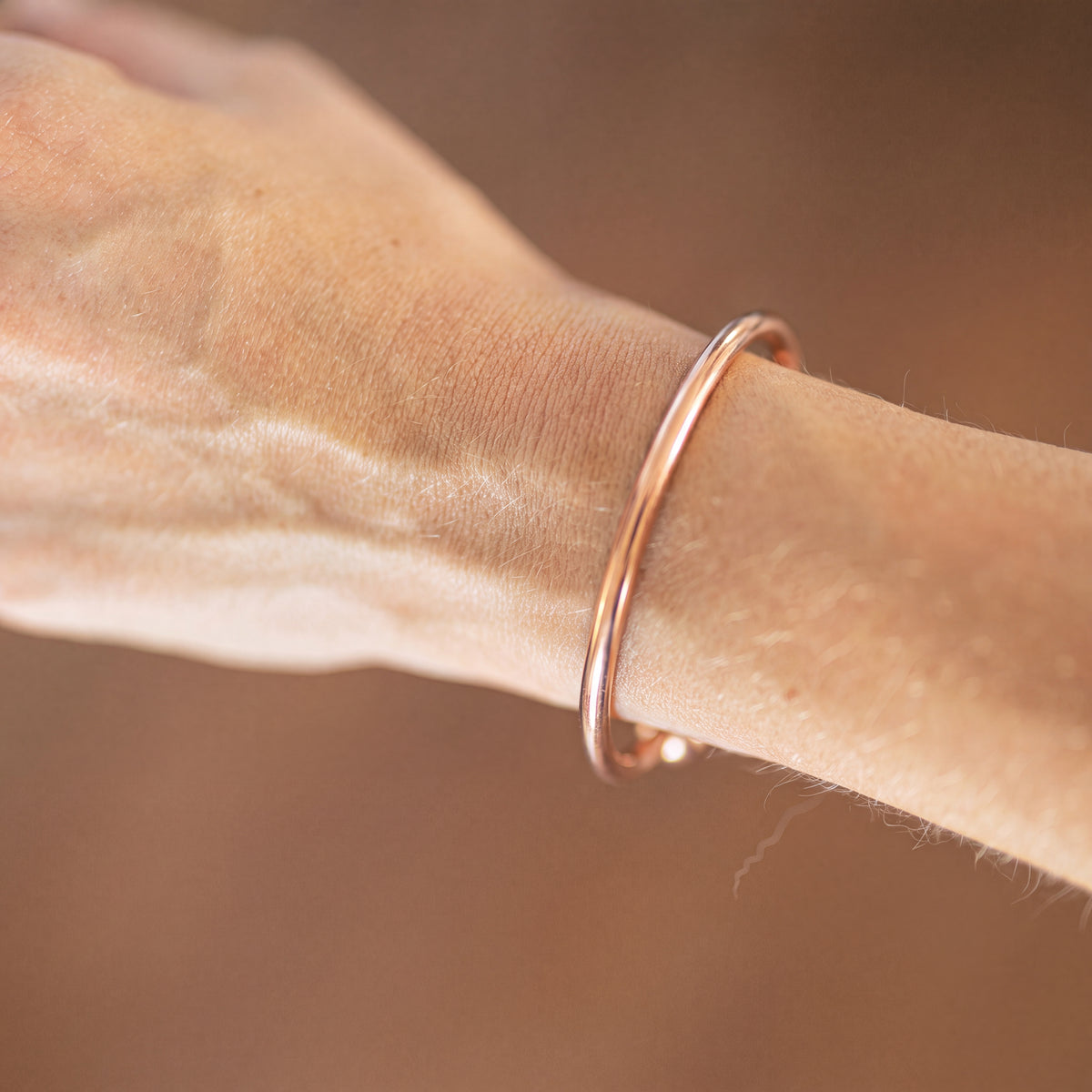 Kopero Premium Kobberarmbånd Rund, close-up af den glatte runde manchet på huden